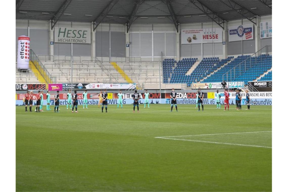 Auch in der leeren Benteler-Arena gedachten die Spieler und Schiedsrichter während einer Schweigeminute den Opfern der Corona-Pandemie. Foto: Friso Gentsch/dpa-Pool/dpa