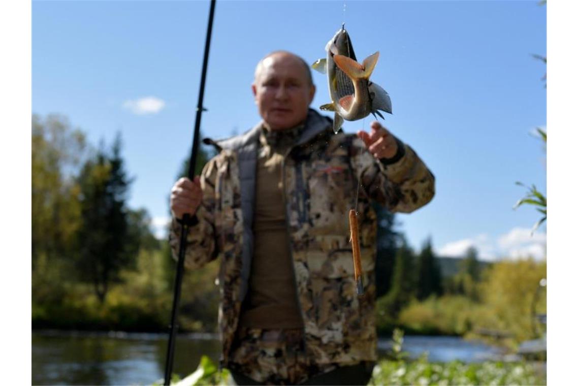 Auch in diesem Jahr wieder unter den Motiven aus Putins Sommerurlaub: Russlands Präsident mit Fisch an der Angel. Foto: Alexei Druzhinin/Pool Sputnik Kremlin/AP/dpa