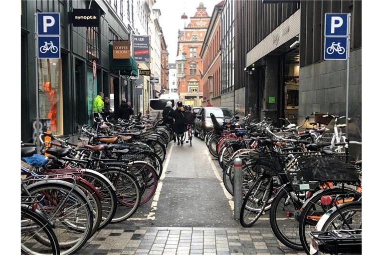 Auch in Kopenhagen gibt es noch ganz klassische Parkhäuser für Autos - direkt daneben ein Fahrradparkplatz. Foto: Steffen Trumpf/dpa