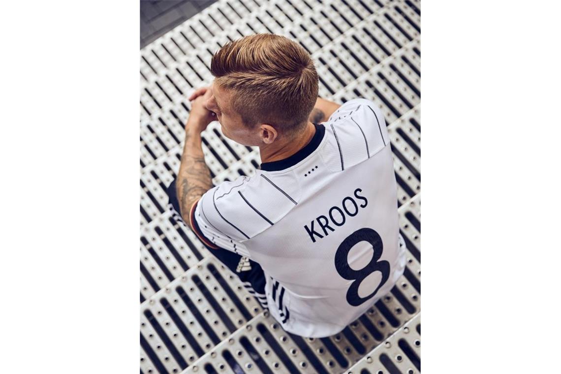 Auch Toni Kroos gefällt das neue DFB-Trikot. Foto: -/adidas/dpa