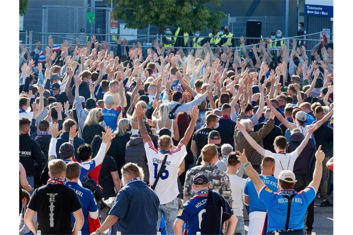 Rettung und Bierdusche: Funkel hält Köln in der Bundesliga Auch vor dem Stadion haben sich zahlreiche Kieler Fans versammelt. Foto: Georg Wendt/dpa