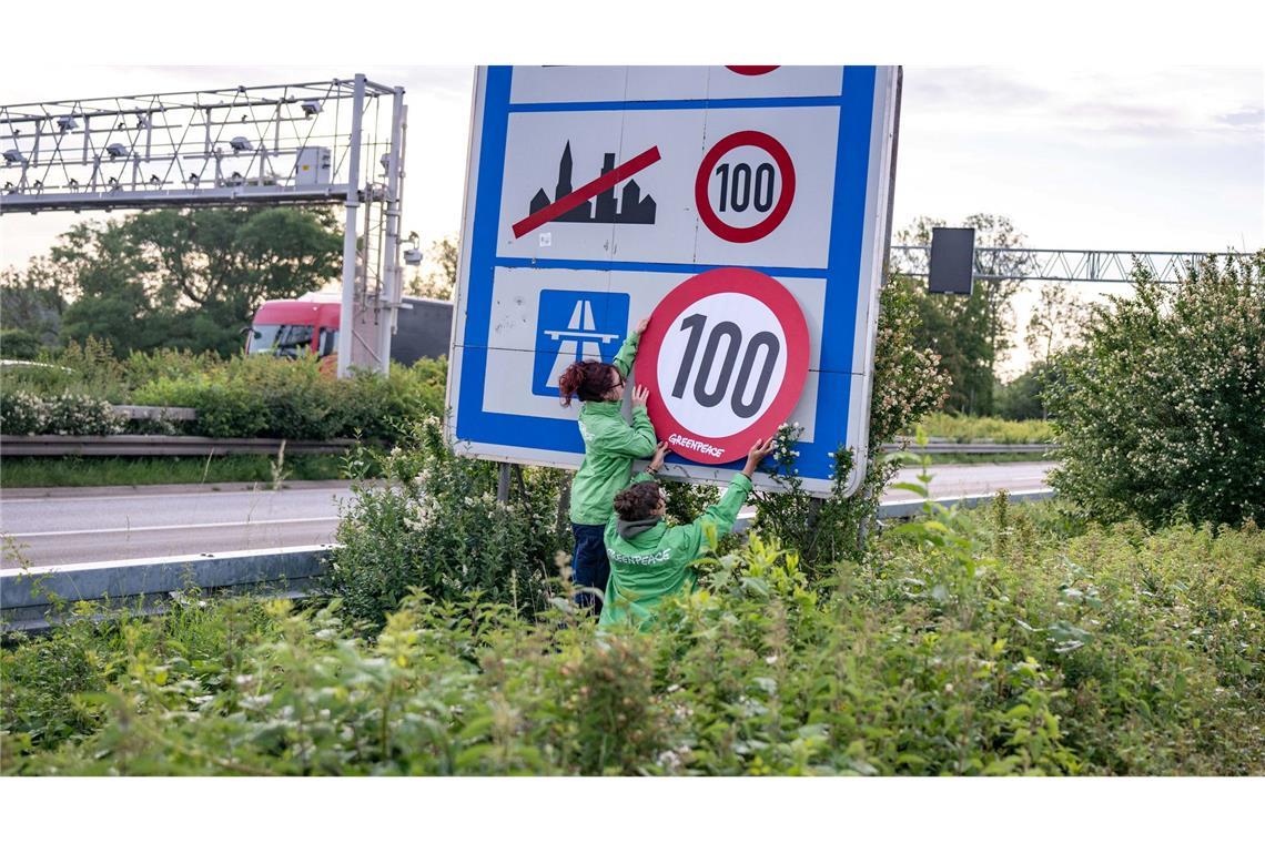 Auf Autobahnen gilt ... ein Tempo-100-Tempolimit? So zumindest wollen es Greenpeace-Aktivistinnen, hier bei der Aktion am Montagmorgen in Aachen.