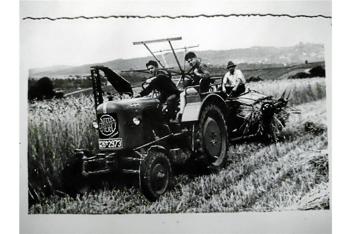 Auf dem Bild sieht man Karl Ellinger (rechts) mit zwei Erntehelfern. Das Foto wurde am 15. August 1955 während des Einsatzes bei der Getreideernte gemacht.