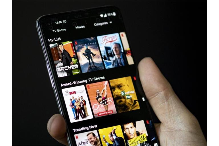 Auf dem Bildschirm eines Smartphones sieht man in der App von Netflix das Filmangebot des Streaminganbieters. Foto: Fabian Sommer/dpa