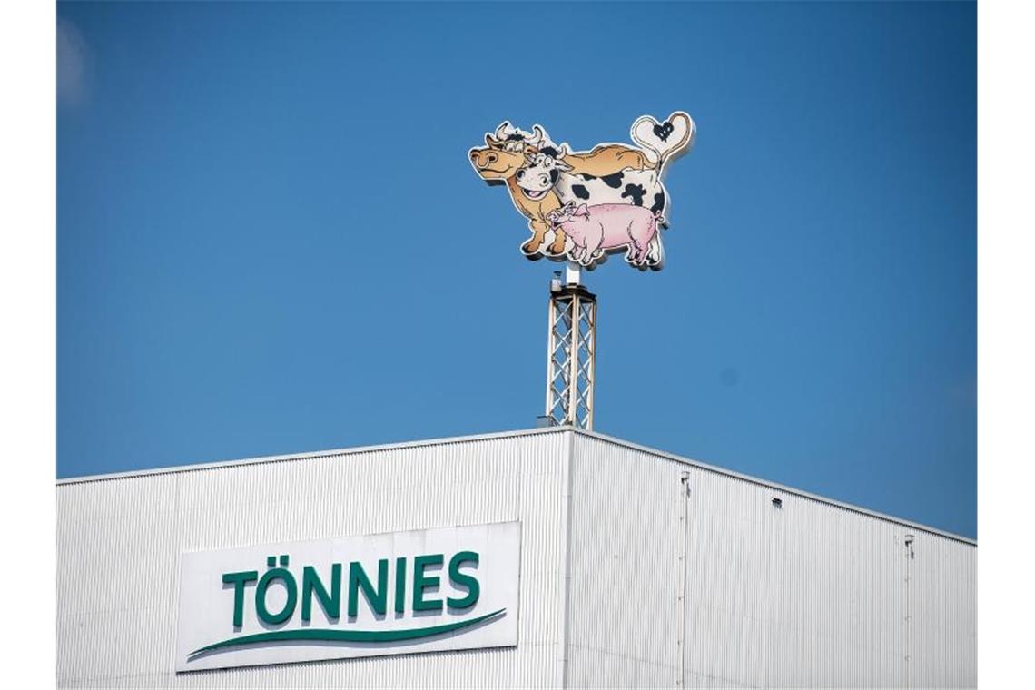 Auf dem Dach eines Gebäudes auf dem Werksgelände steht das Logo der Firma Tönnies in Form von zwei Kühen und einem Schwein. Foto: Guido Kirchner/dpa