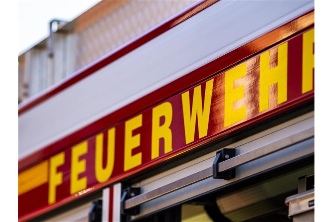 Auf dem Einsatzfahrzeug ist in gelber Farbe der Schriftzug „Feuerwehr“ zu lesen. Foto: David Inderlied/dpa/Symbolbild