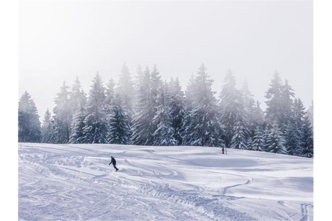 Auf dem Feldberg fährt ein Snowboarder eine Piste herunter. Foto: Philipp von Ditfurth/dpa