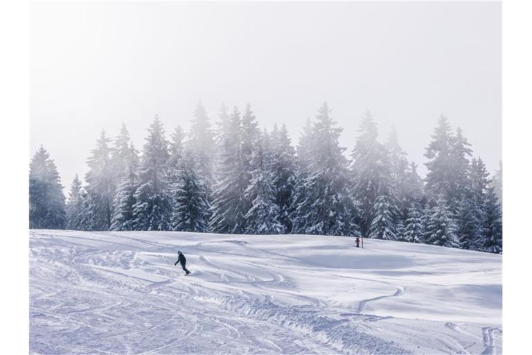 Auf dem Feldberg fährt ein Snowboarder eine Piste herunter. Foto: Philipp von Ditfurth/dpa