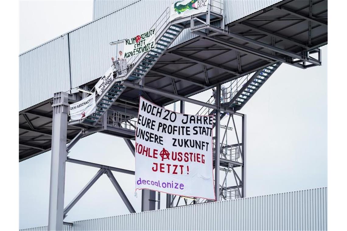 Auf dem Förderband hängt ein Transparent „Noch 20 Jahre eure Profite statt unsere Zukunft - Kohleaustieg jetzt!„. Foto: Uwe Anspach