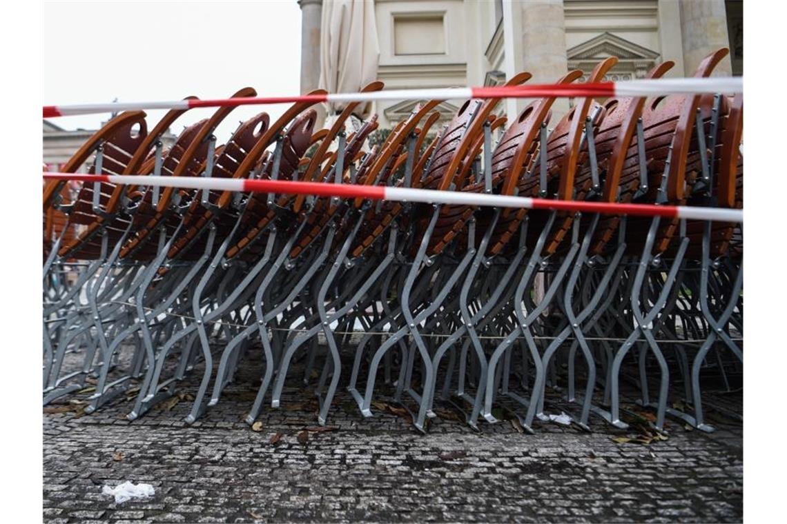 Die Beschlüsse gegen das Coronavirus im Detail Auf dem Gendarmenmarkt in Berlin stehen zusammengestapelte Stühle hinter einem Absperrband. Foto: Kira Hofmann/dpa-Zentralbild/dpa