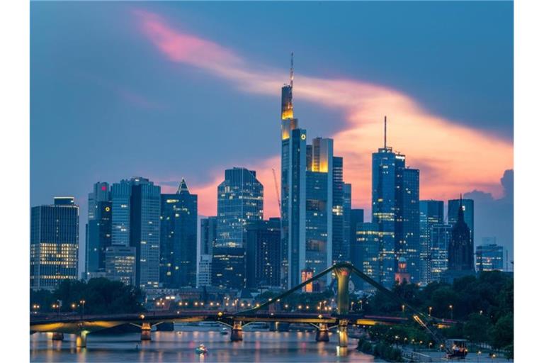 Auf dem Main fährt ein Schiff vor der Skyline der Bankenmetropole. Foto: Boris Roessler/dpa