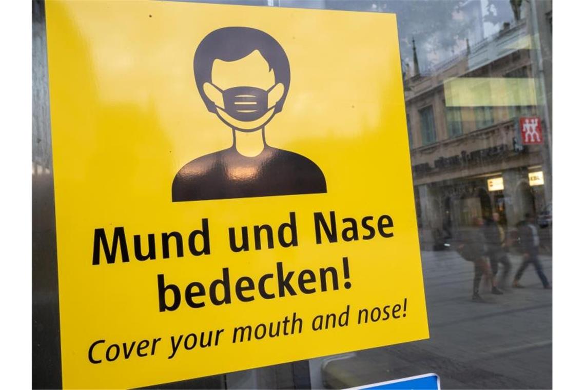 Auf dem Münchener Marienplatz fordert ein Schild zum Tragen eine Mund-Nasen-Bedeckung auf. Foto: Peter Kneffel/dpa