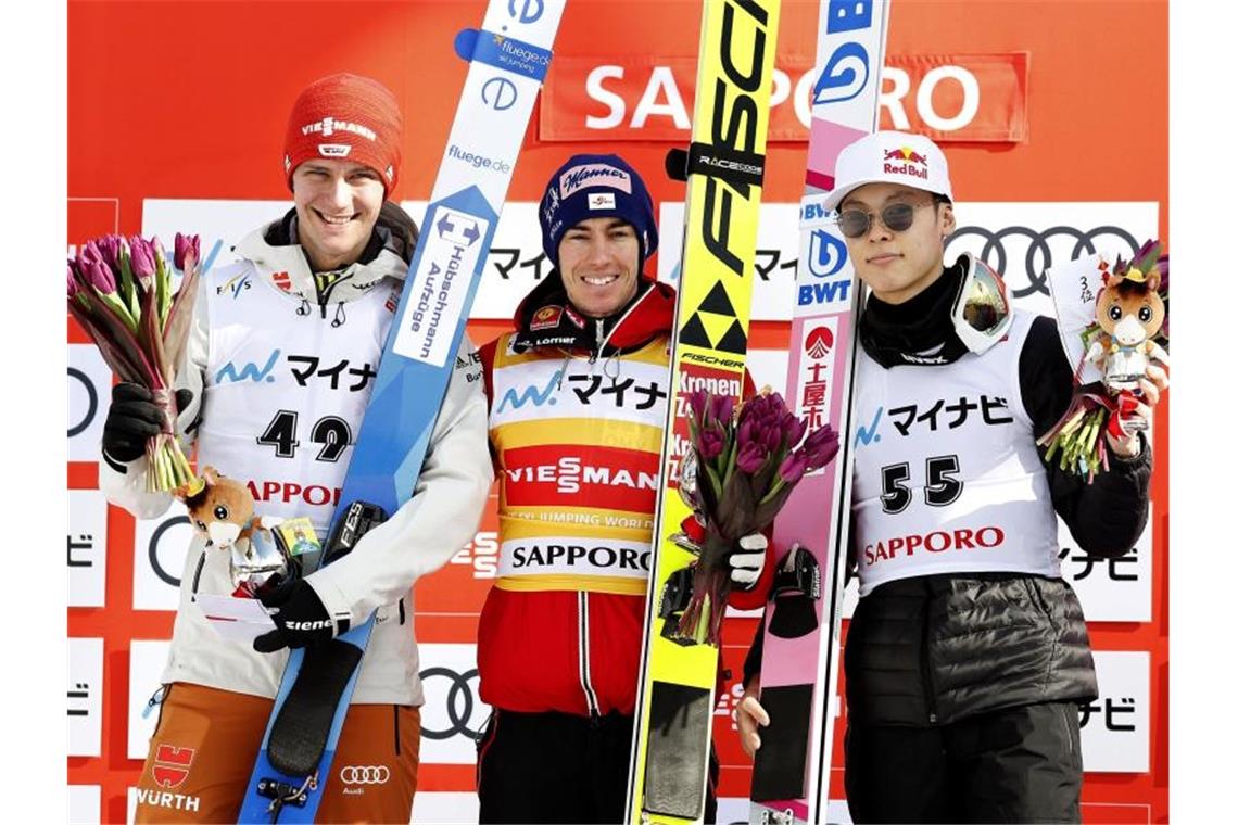 Auf dem Podest in Sapporo: Sieger Stefan Kraft (M) steht zwischen Stephan Leyhe (l) und dem Japaner Ryoyu Kobayashi. Foto: kyodo/dpa