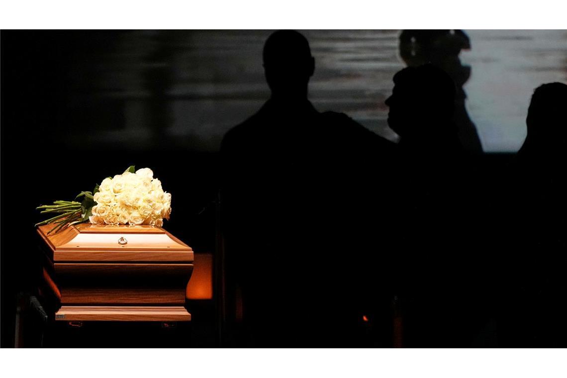 Abschied von Armani: Lange Schlangen am Sarg Auf dem Sarg liegt ein Strauß weißer Rosen.