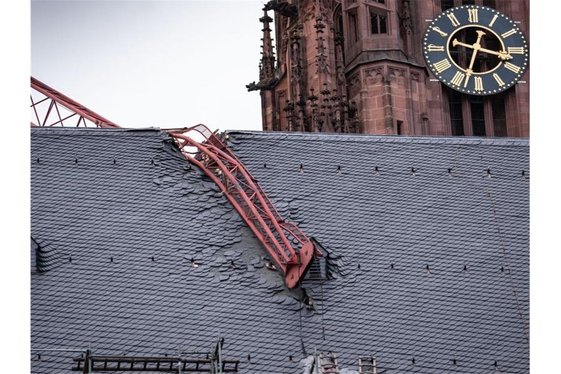 Auf den Frankfurter Dom gekracht: Der beschädigte Baukran wird vorerst gesichert und kann voraussichtlich erst Mitte der Woche entfernt werden. Foto: Frank Rumpenhorst/dpa