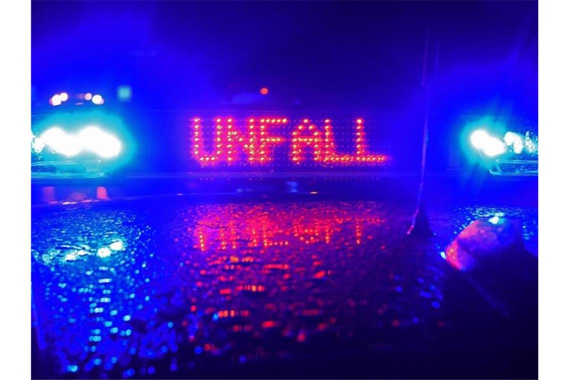 Auf der A8 spiegeln sich während einer Unfallaufnahme das Blaulicht und der LED- Schriftzug "Unfall". Foto: Stefan Puchner/dpa