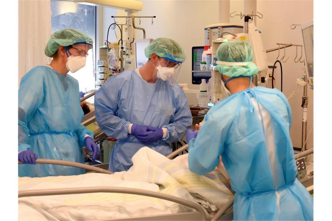 Intensivmediziner befürchten Überlastung durch Covid-Kranke Auf der Covid-Station, einem Bereich der Operativen Intensivstation vom Universitätsklinikum Leipzig, stehen Mitarbeiter am Bett eines schwerkranken Patienten. Foto: Waltraud Grubitzsch/dpa-Zentralbild/dpa