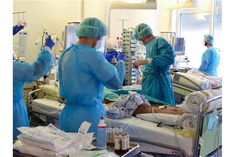 Auf der Covid-Station vom Universitätsklinikum Leipzig versorgen Ärzte, Schwestern und Pfleger einen Patienten. Foto: Waltraud Grubitzsch/dpa-Zentralbild/dpa