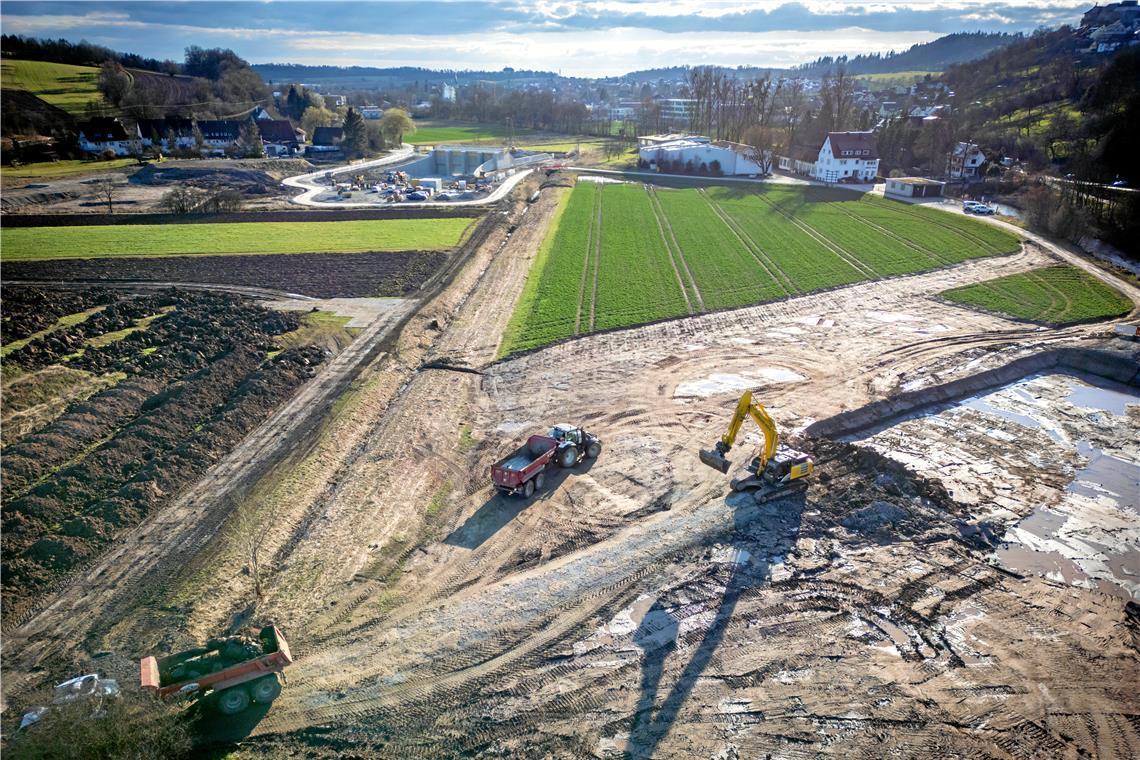 Ein Meilenstein im Kampf gegen die Fluten im Murrtal Auf der Drohnenaufnahme ist die Lage des neuen Wehrs bereits erkennbar. Der Aushub des Bauwerks wird seitlich deponiert. Im Hintergrund ist das Durchlassbauwerk zu sehen.