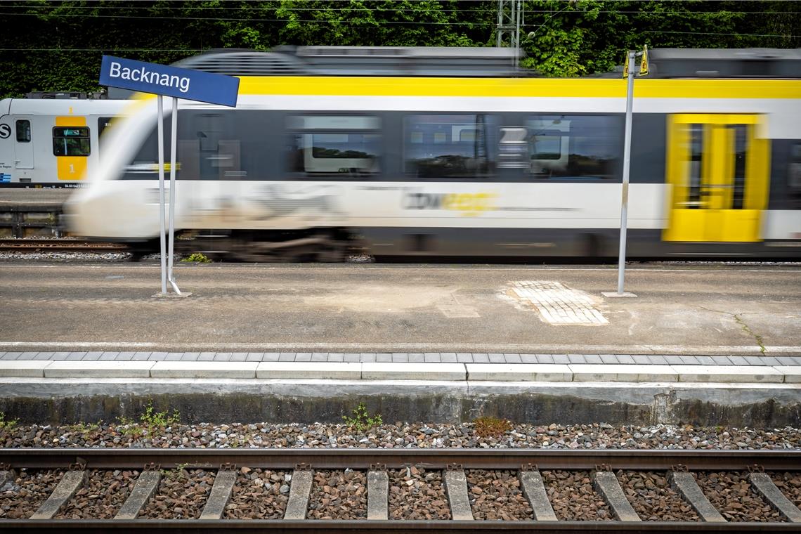 Mann fährt auf Kupplung eines Regionalzugs mit