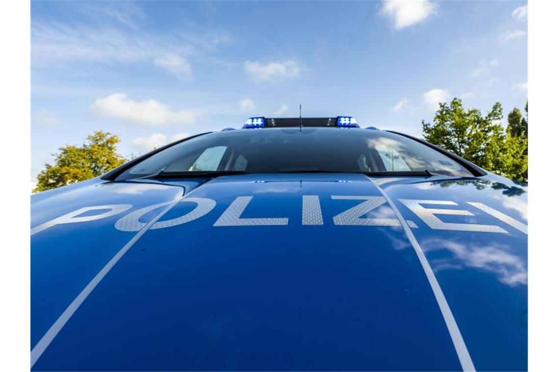 Mann schlägt Zugbegleiterin Auf der Motorhaube eines Streifenwagens steht der Schriftzug „Polizei“. Foto: David Inderlied/dpa/Illustration