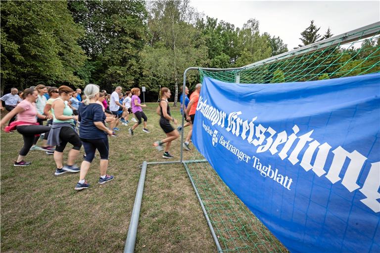 Auf der Wiese des Spielplatzes im Plattenwald wärmen die Sportler ihre Muskeln auf und bringen den Kreislauf in Schwung. Foto: Alexander Becher