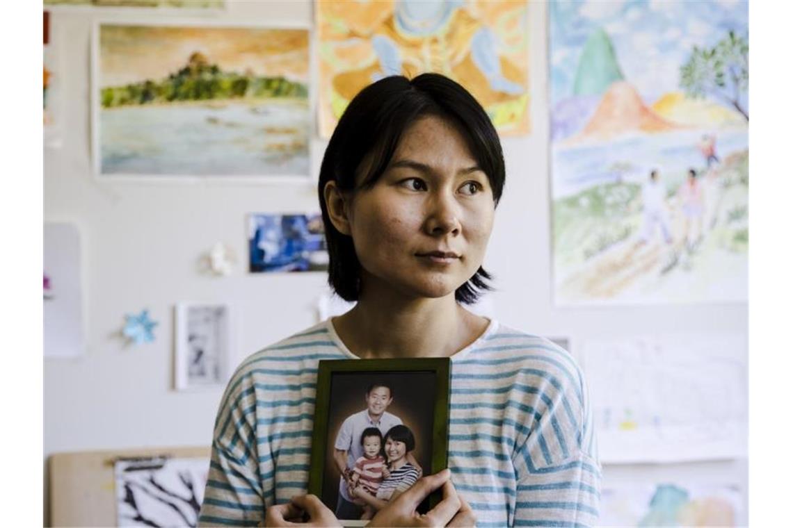 Auf diesem am 07.12.2019 zur Verfügung gestellten Foto sitzt Hua Qu, die Frau des inhaftierten chinesisch-amerikanischen Historiker Xiyue Wang mit einem Porträt ihrer Familie in Princeton. Foto: Matt Rourke/AP/dpa