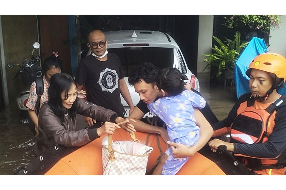Urlauber müssen mit Booten gerettet werden Auf diesem von der Nationalen Such- und Rettungsbehörde Indonesiens (BASARNAS)veröffentlichten Foto evakuieren Rettungskräfte Bewohner aus ihrem überfluteten Haus in Denpasar auf Bali.