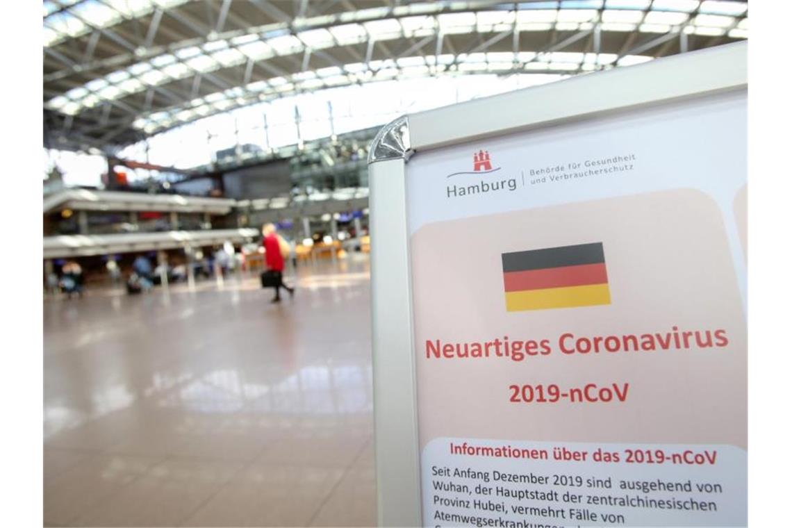 Auf einem Aufsteller der Gesundheitsbörde und des Robert Koch-Instituts wird im mäßig gefüllten Hamburger Flughafen auf Verhaltensweisen in Bezug auf das Coronavirus hingewiesen. Foto: Bodo Marks/dpa