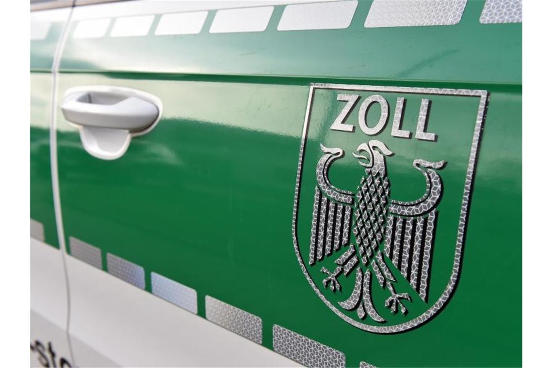 Zoll pfändet Reisebus: Passagiere müssen umsteigen Auf einem Fahrzeug klebt das Wappen des Zolls. Foto: Caroline Seidel/dpa/Archivbild