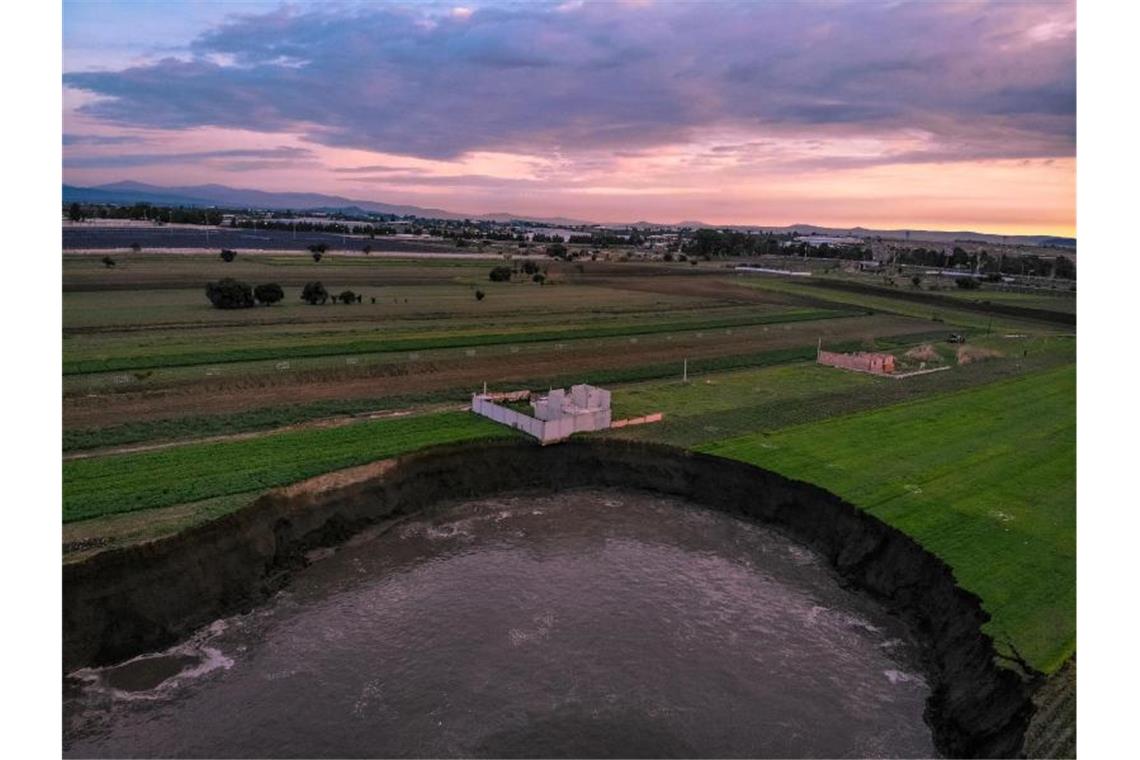 Riesiger Krater in Mexiko gibt Rätsel auf Auf einem Feld in Zentralmexiko hat sich ein großer mit Wasser gefüllter Krater aufgetan. Das einzige Haus in der Nähe sei gefährdet. Foto: Karlos Pinpunk/dpa