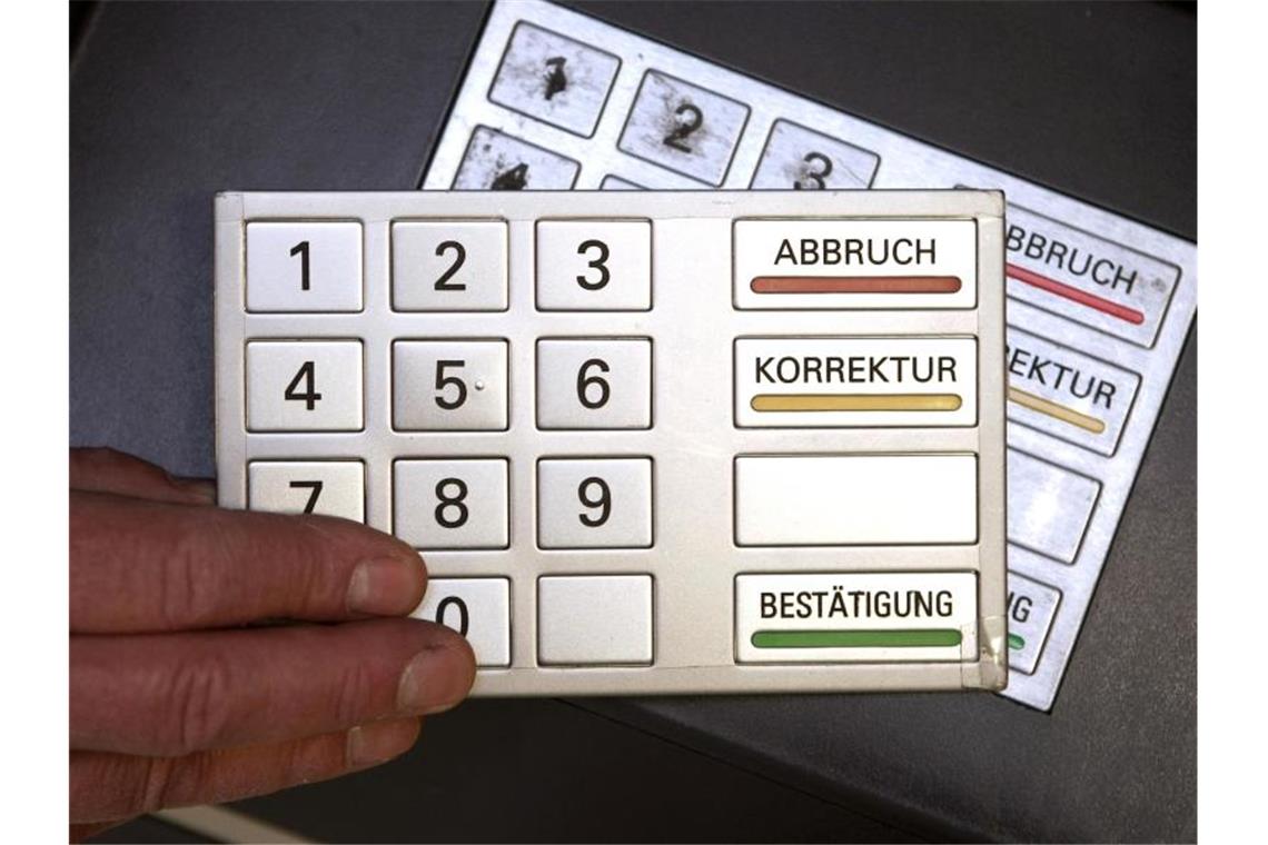 Kartendiebe trotz moderner Technik immer noch erfolgreich Auf einem Modell-Bankautomaten wird ein täuschend echt aussehendes zweites Tastenfeld angebracht. Foto: Fredrik von Erichsen/dpa