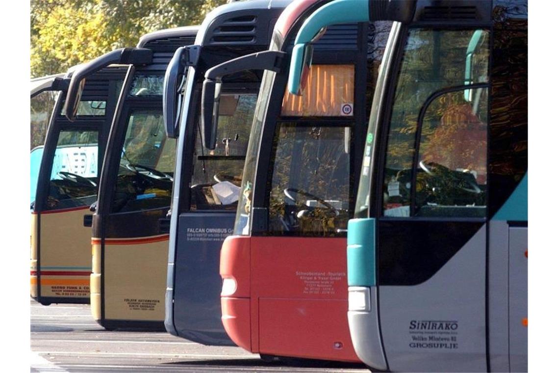 Auf einem Parkplatz stehen mehrere Omnibusse. Foto: Frank Mächler/dpa