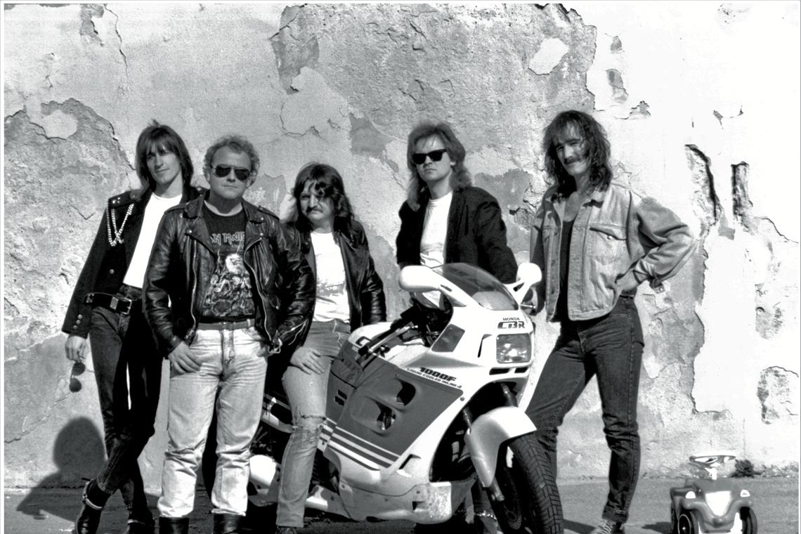 Auf einem Pressefoto posiert die Band Ende der 80er um ein Motorrad. (Von links): Klaus Weller, Klaus Warstat, Hans Lang, Dieter Ebel und Thomas Grollmus. Foto: Bad Boyz