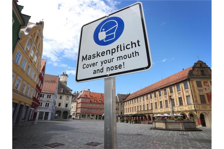 Auf einem Schild am Rathausplatz wird auf Maskenpflicht hingewiesen. Foto: Karl-Josef Hildenbrand/dpa/Archivbild