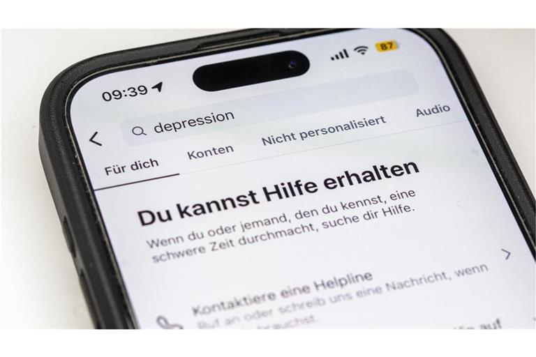 Auf einem Smartphone ist eine Suchansicht innerhalb einer Social-Media-App zu sehen, die bei dem Begriff „Depression“ Hinweise auf Hilfsangebote und Unterstützung einblendet. Plattformen wie Instagram zeigen bei sensiblen Suchbegriffen zunehmend Sicherheitshinweise und Verlinkungen zu professionellen Beratungsstellen. Sie reagieren damit auf die wachsende Rolle sozialer Medien bei der Informationssuche zu psychischen Belastungen.