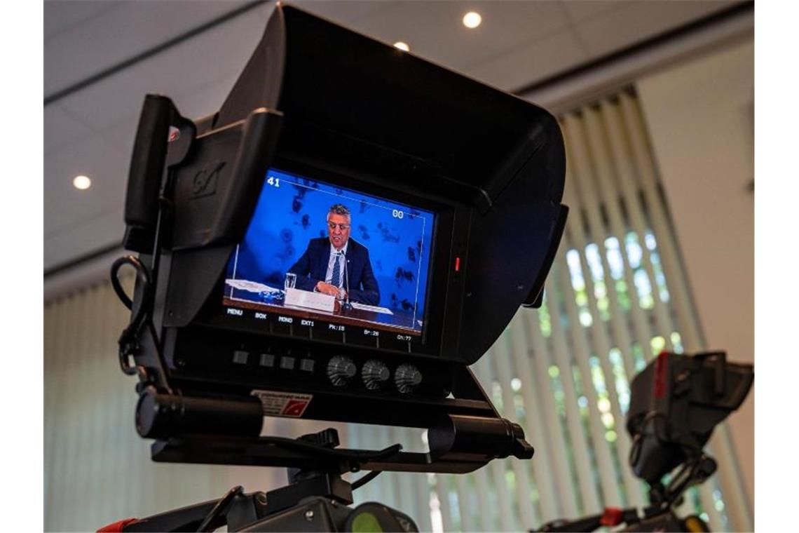 Fast 600 registrierte Corona-Neuinfektionen Auf einem Videomonitor ist Lothar H. Wieler, Präsident des Robert Koch-Instituts (RKI), zu sehen. Foto: John Macdougall/AFP-Pool/dpa