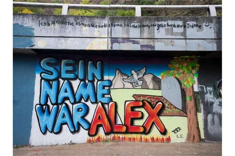 Auf einer Mauer entlang ein Graffiti "Sein Name war Alex" für den getöteten Tankstellen-Mitarbeiter gemalt. Foto: Oliver Dietze/dpa