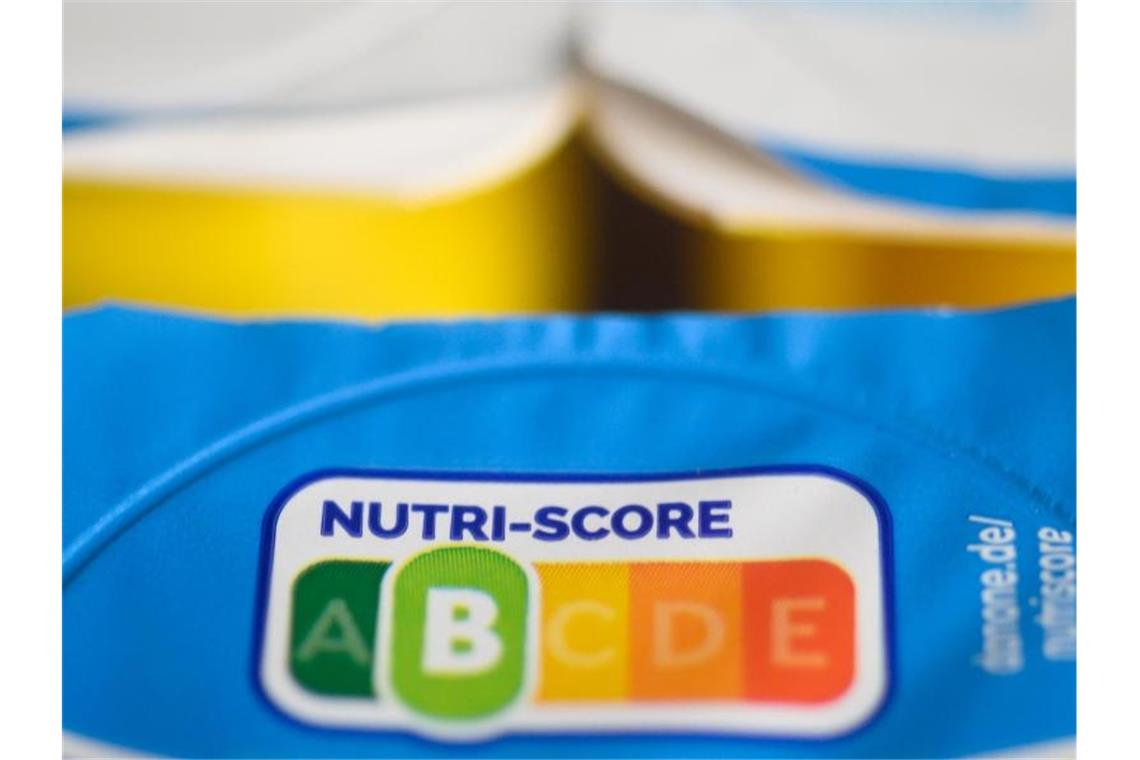 Auf einer Packung Joghurt ist der sogenannte „Nutri-Score“ zu sehen. Das neue farbige Logo Nutri-Score soll ab November auf breiter Front starten können, damit Kunden gesündere Lebensmittel beim Einkauf leichter erkennen. Foto: Christophe Gateau/dpa