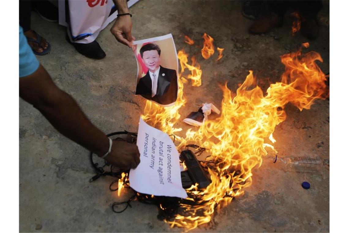 Auf einer Straße im indischen Ahmedabad wird ein Foto des chinesischen Präsidenten Xi Jinping verbrannt. Foto: Ajit Solanki/AP/dpa
