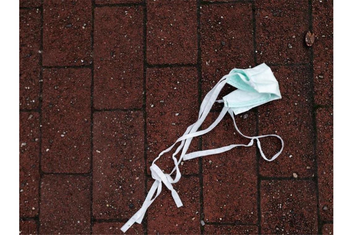 Sozialministerium: Derzeit kein Anlass für Shutdwon Auf einer Straße liegt ein Mund-Nasen-Schutz auf dem Boden. Foto: Fabian Strauch/dpa/Symbolbild