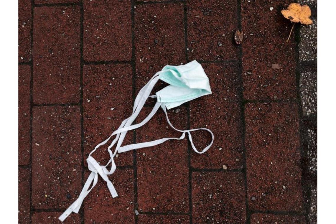 Richter kippen strenge Maskenpflicht im Rems-Murr-Kreis Auf einer Straße liegt ein Mund-Nasen-Schutz auf dem Boden. Foto: Fabian Strauch/dpa/Symbolbild