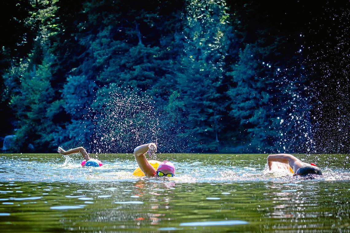 Auf ihrer Runde durch den Ebnisee genießen es Mia Meyer, Pia Jelica und Paris Pappas (von links), anders als im Becken nicht ständig wenden zu müssen. Fotos: Alexander Becher