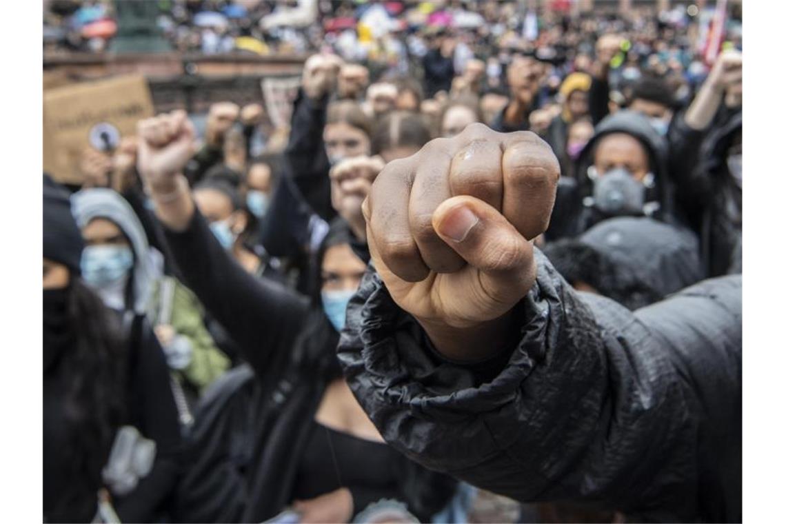 Auf Knien und mit in die Höhe gestreckter Faust bekunden Demonstranten auf dem Römerberg in Frankfurt ihre Solidarität mit den Anti-Rassismus-Protesten in den USA. Foto: Boris Roessler/dpa