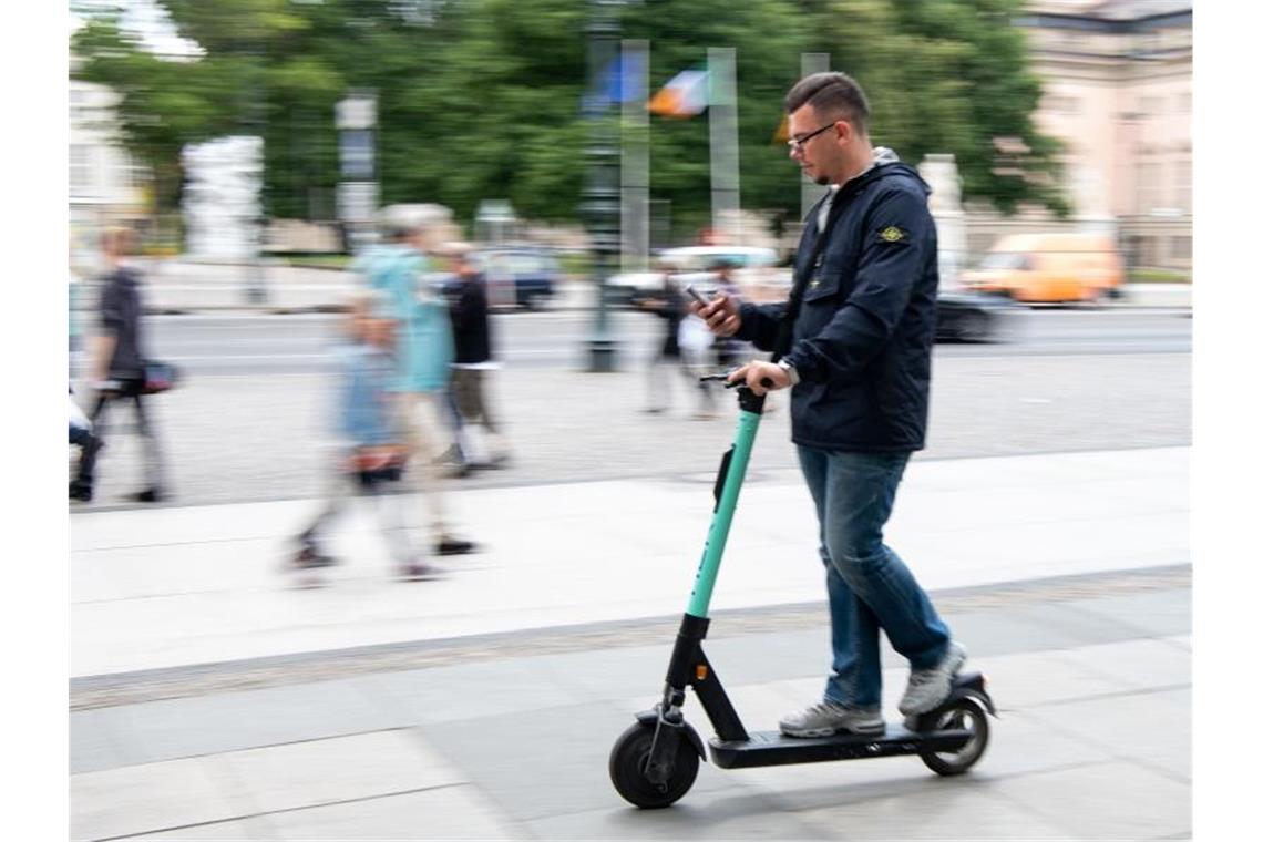 Auf zwei winzigen Rädern im Innenstadtverkehr, die Augen fest aufs Handy geheftet: Ein Tourist fährt durch Berlin-Mitte. Foto: Bernd von Jutrczenka