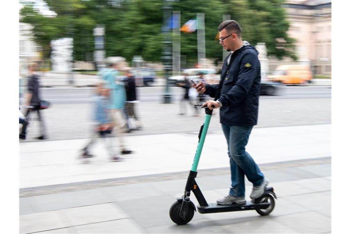 Scheuer für härteres Durchgreifen bei E-Tretrollern Auf zwei winzigen Rädern im Innenstadtverkehr, die Augen fest aufs Handy geheftet: Ein Tourist fährt durch Berlin-Mitte. Foto: Bernd von Jutrczenka