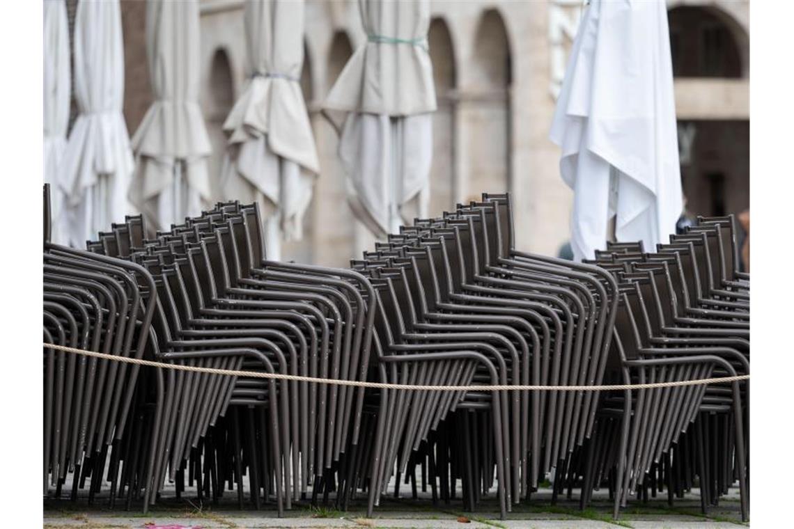 Aufeinander gestapelte Stühle eines geschlossenen Gastronomiebetriebs. Foto: Marijan Murat/dpa