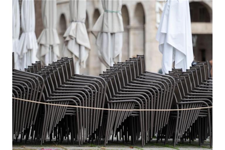 Aufeinander gestapelte Stühle eines geschlossenen Gastronomiebetriebs. Foto: Marijan Murat/dpa