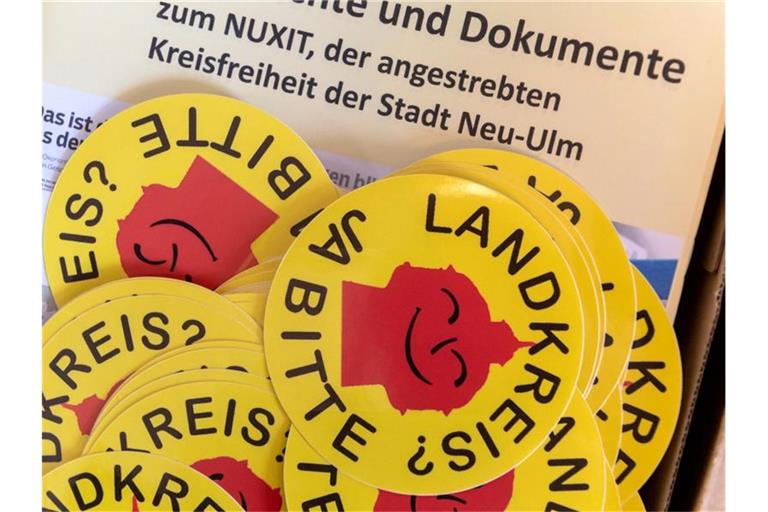 Aufkleber mit der Aufschrift "Landkreis? - Ja Bitte" liegen im Bayerischen Landtag. Foto: Peter Kneffel/Archivbild