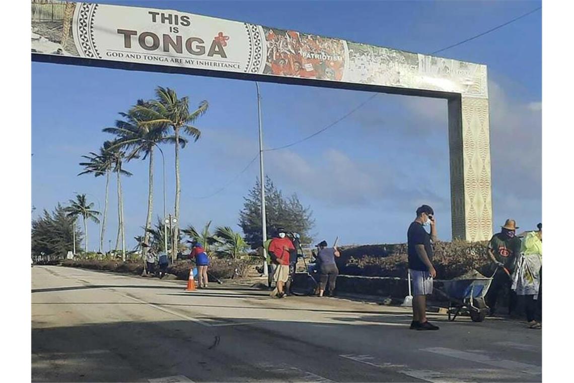 Erste Hilfsflüge landen in Tonga - Angst vor dem Virus Aufräumarbeiten auf einer Straße in Nuku'alofa. Sechs Tage nach der Eruption eines Untersee-Vulkans vor Tonga ist der Flughafen des Südsee-Archipels wieder funktionsfähig. Foto: Marian Kupu/Broadcom Broadcasting/AP/dpa